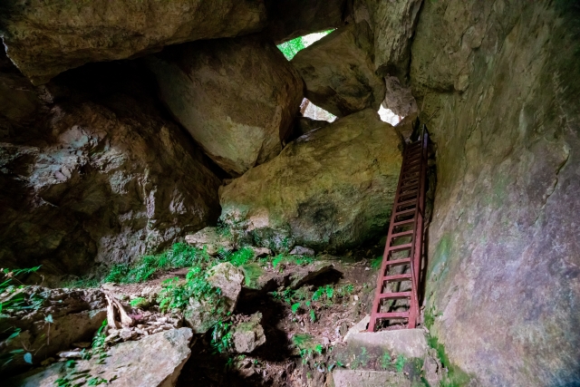 Inside a low cave, small Buddhist Kannon statues set among breast-shaped stalactites on the ceiling.
