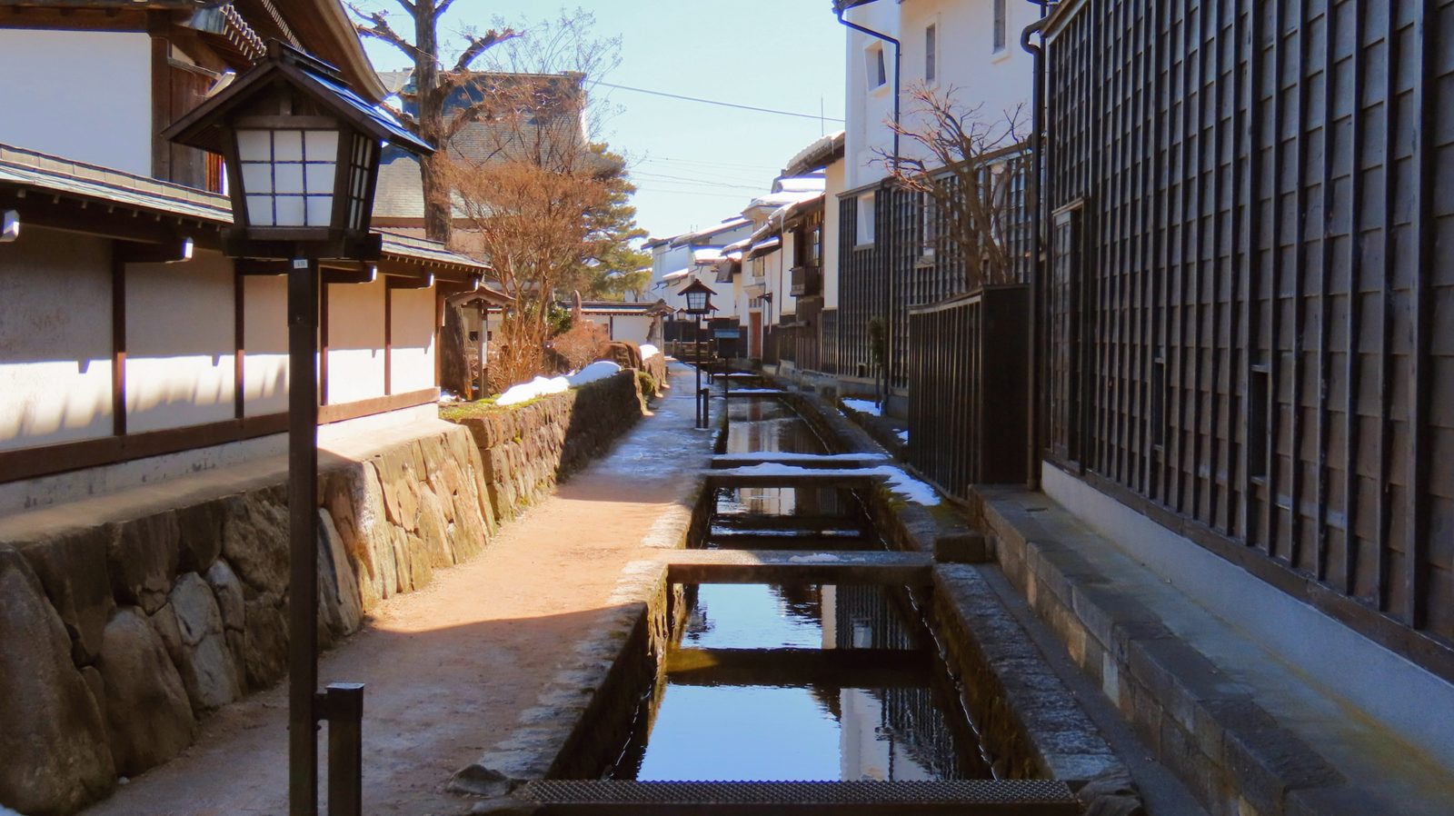 The storehouse lane along the Setogawa in winter, snow lying on the stone and plaster.