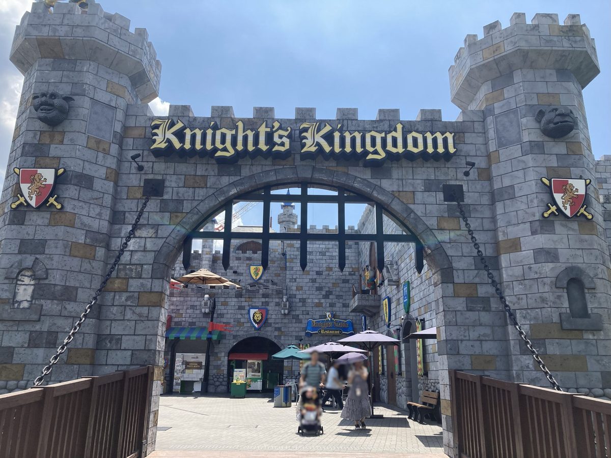 The grey stone Knight's Kingdom castle gate, framed by towers and shields