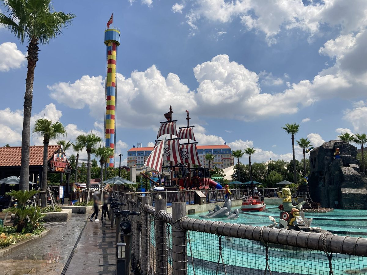 A pirate-themed water play zone with a ship and tall striped drop tower