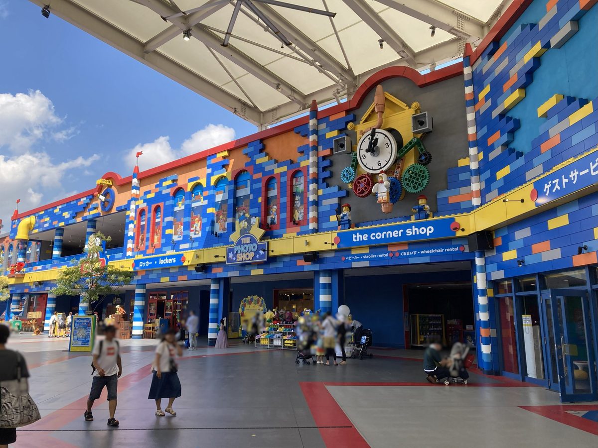 A plaza of brick-clad shops gathered beneath a large LEGO clock tower