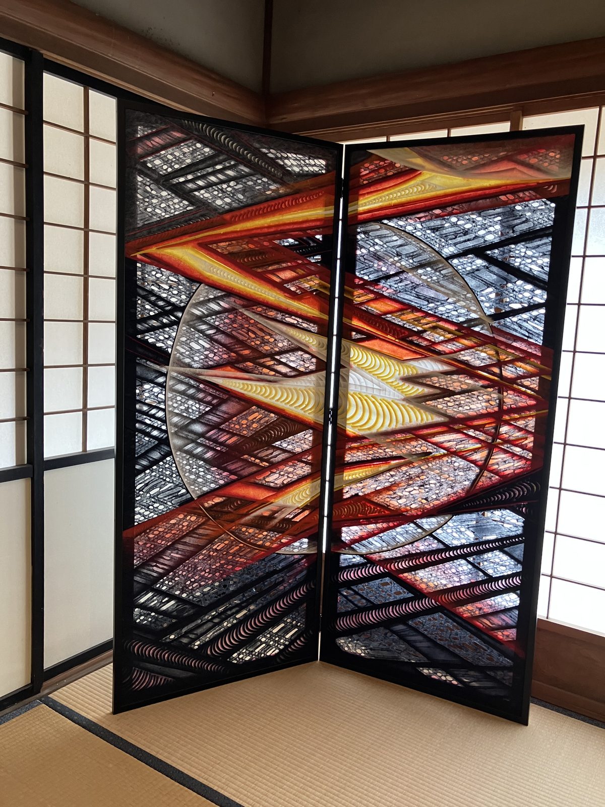 A two-panel folding screen of vivid red and silver washi art.