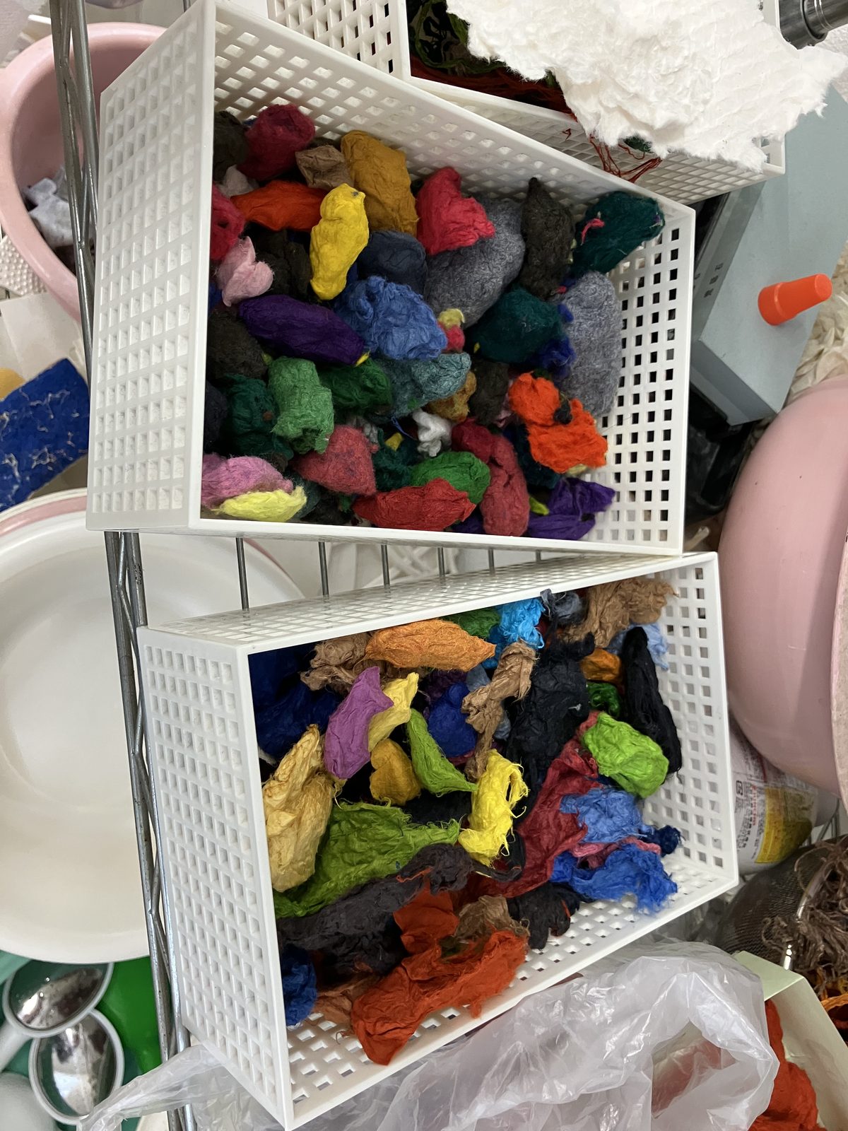 Baskets of brightly dyed washi pulp, ready to be worked into pictures.