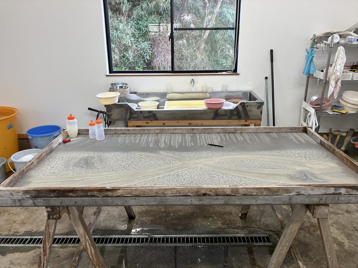 The large papermaking vat where a pattern is laid into the wet pulp.