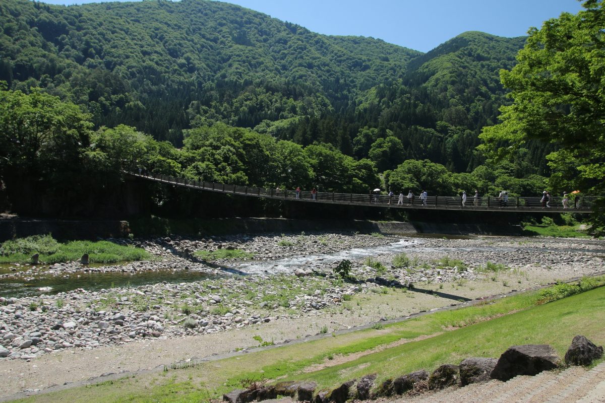 The Deai suspension bridge over the Sho River in summer green