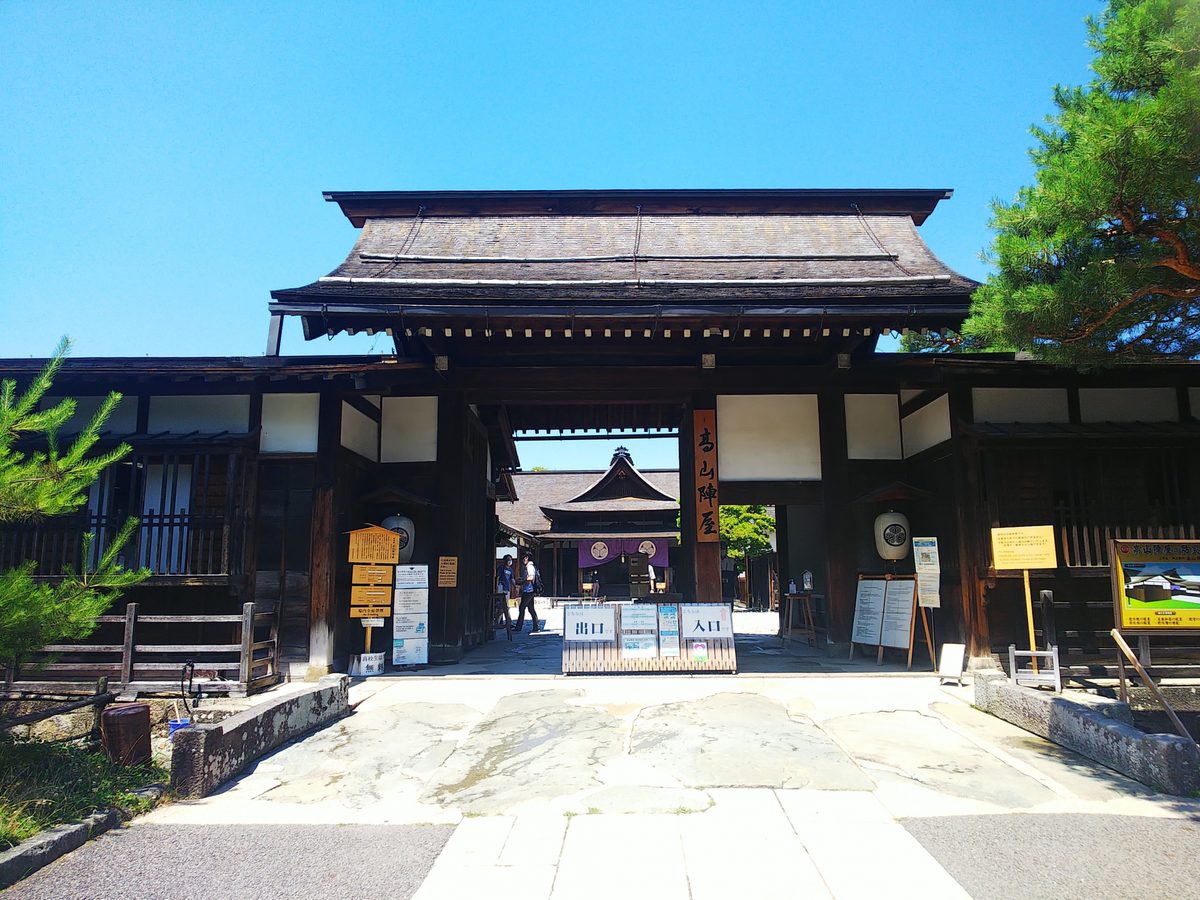 The tiled main gate of Takayama Jinya under a clear blue sky