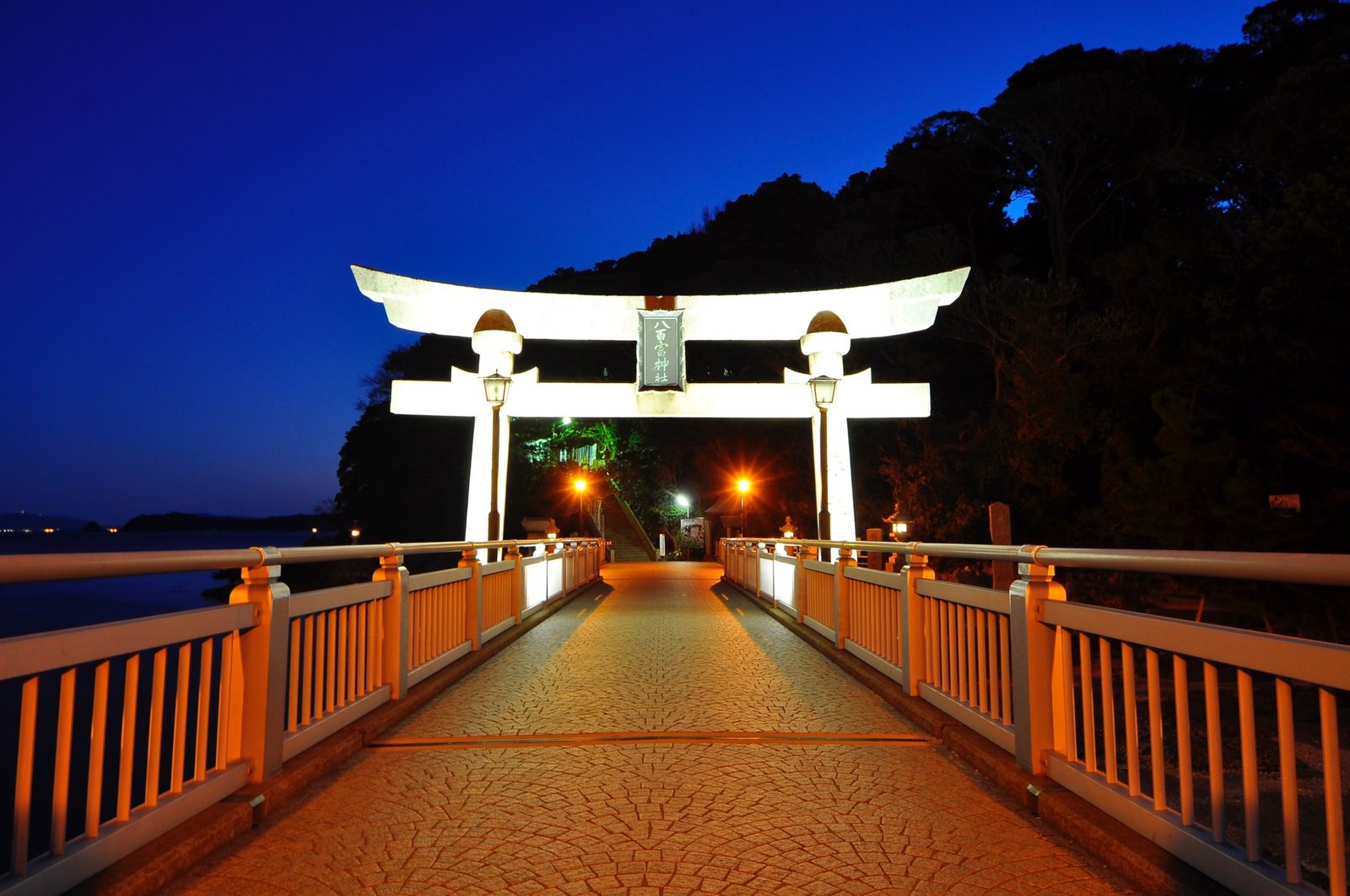 Yaotomi Shrine's torii gate, lit up in the blue light of dusk.