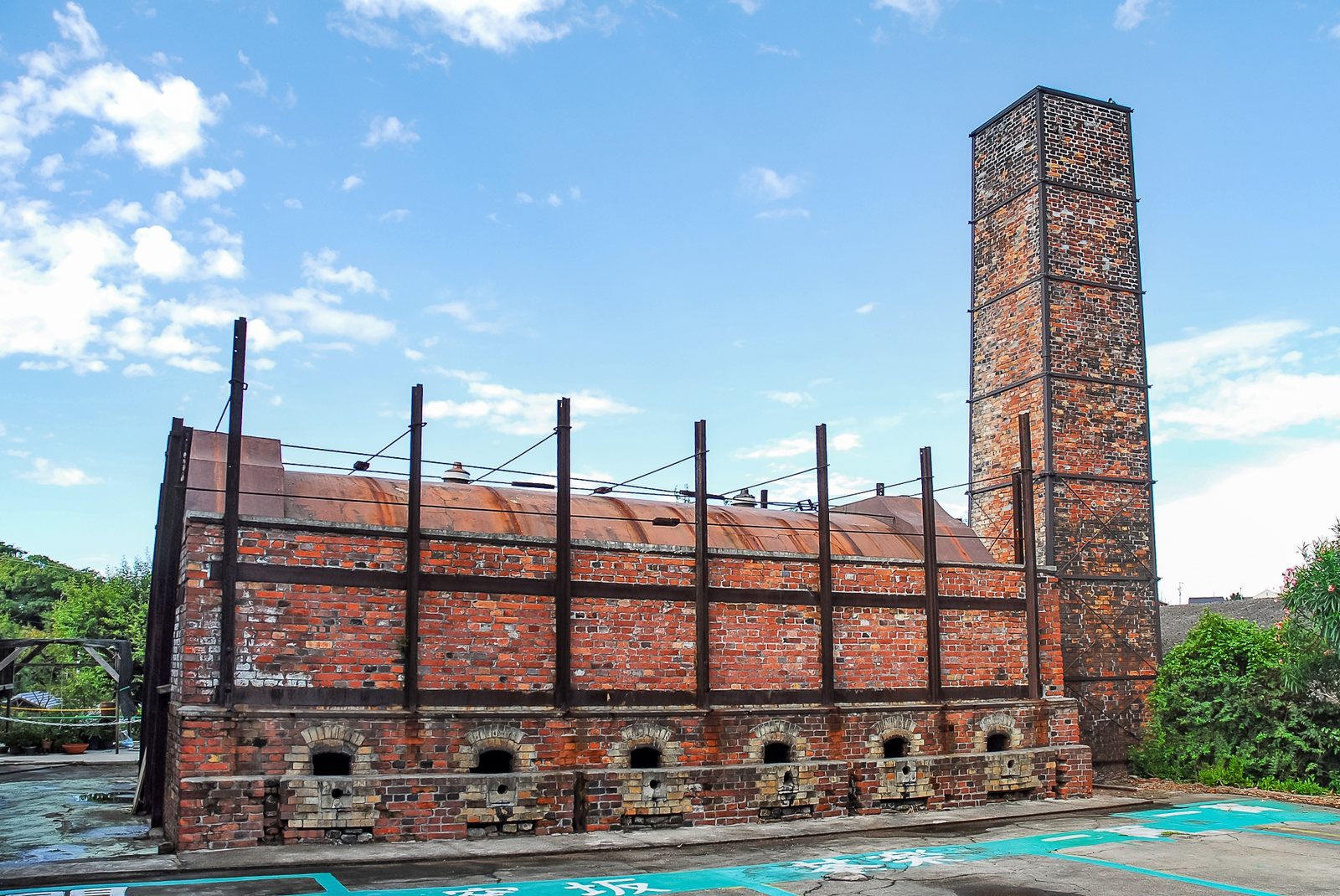 The long brick climbing kiln stepping up the hillside, its row of chimneys against the sky.